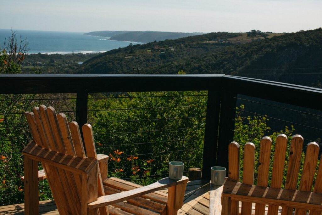 Eco-living and nature immersion in Hoekwil at Mountain Magic with wooden deck chairs overlooking scenic mountain and ocean views